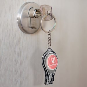 "Llavero de metal con función de cortauñas y abrebotellas, compacto y funcional"